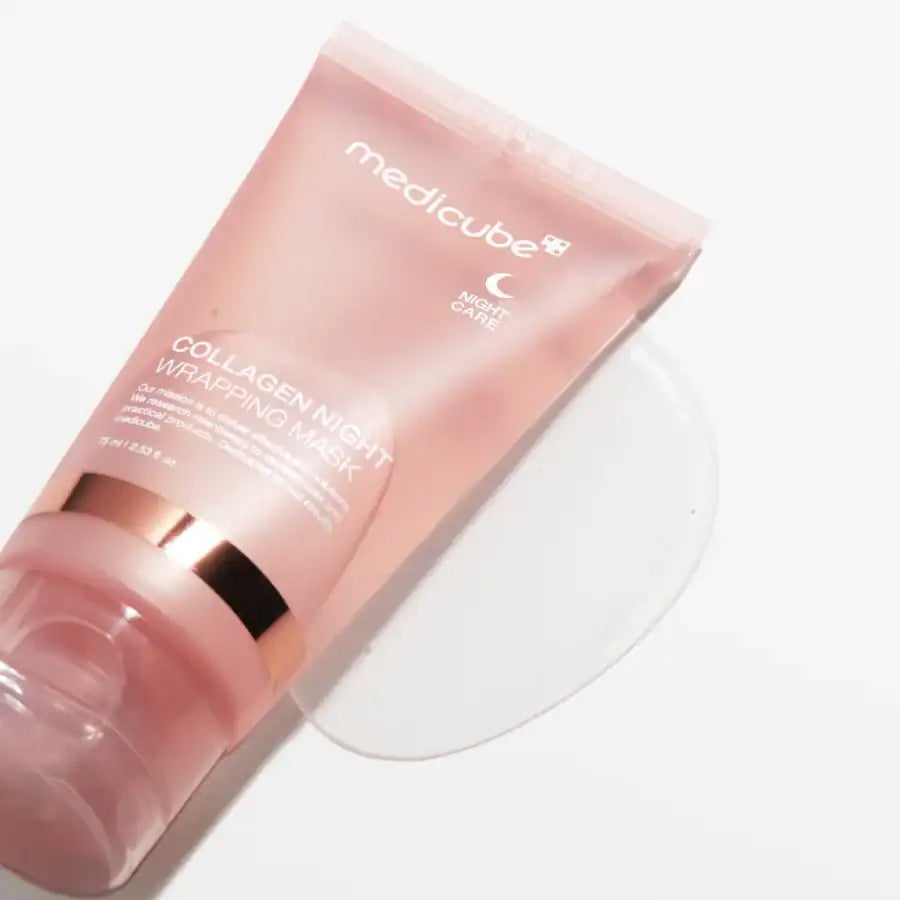 Medicube Collagen Night Wrapping Mask 75ml i rosa tube ligger på hvid baggrund med lidt gel omkring åbningen.