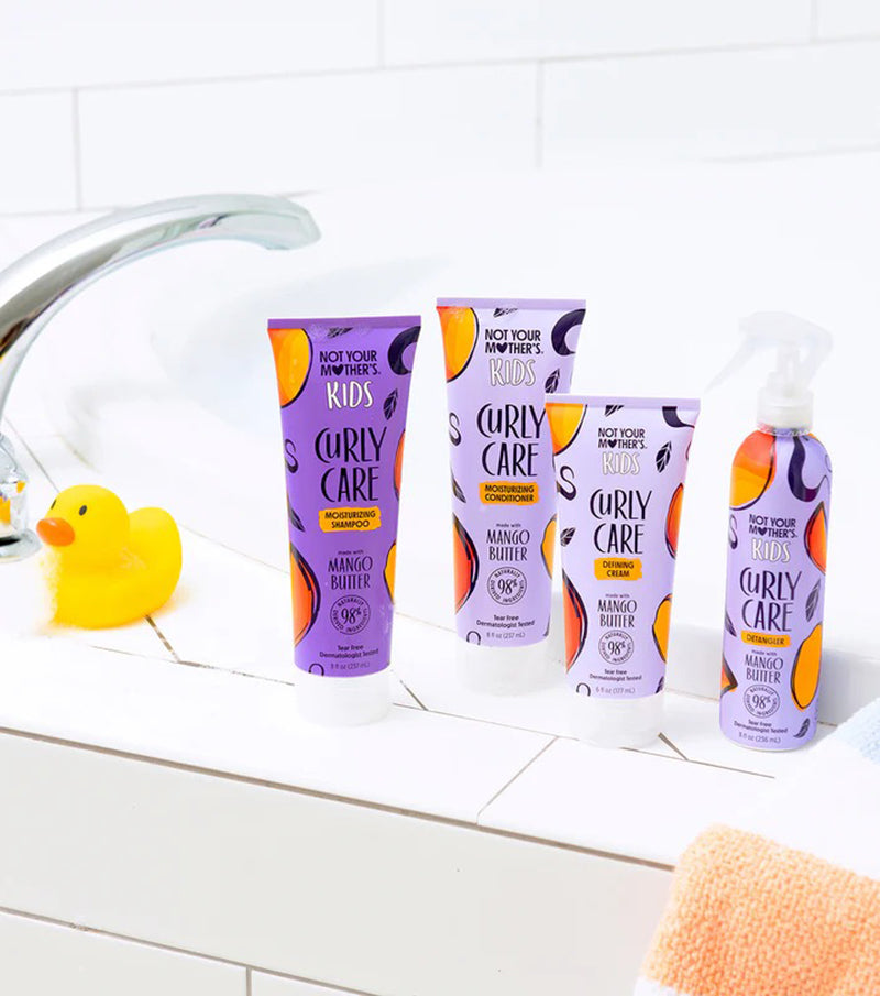 Not Your Mother's Kids Curly Care Cream 237ml står ved badekar sammen med andre produkter med farverig, lilla emballage.