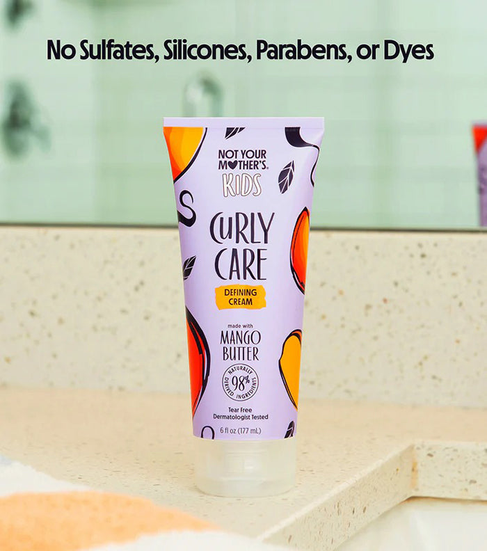 Not Your Mother's Kids Curly Care Cream 237ml på badeværelsesbord, lilla tube med farverige frugtmotiver og mango smør.