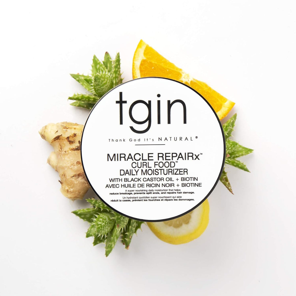 TGIN Miracle RepairX Curl Food 340gr omgivet af aloe vera, ingefær, citronskive og appelsin på hvid baggrund.